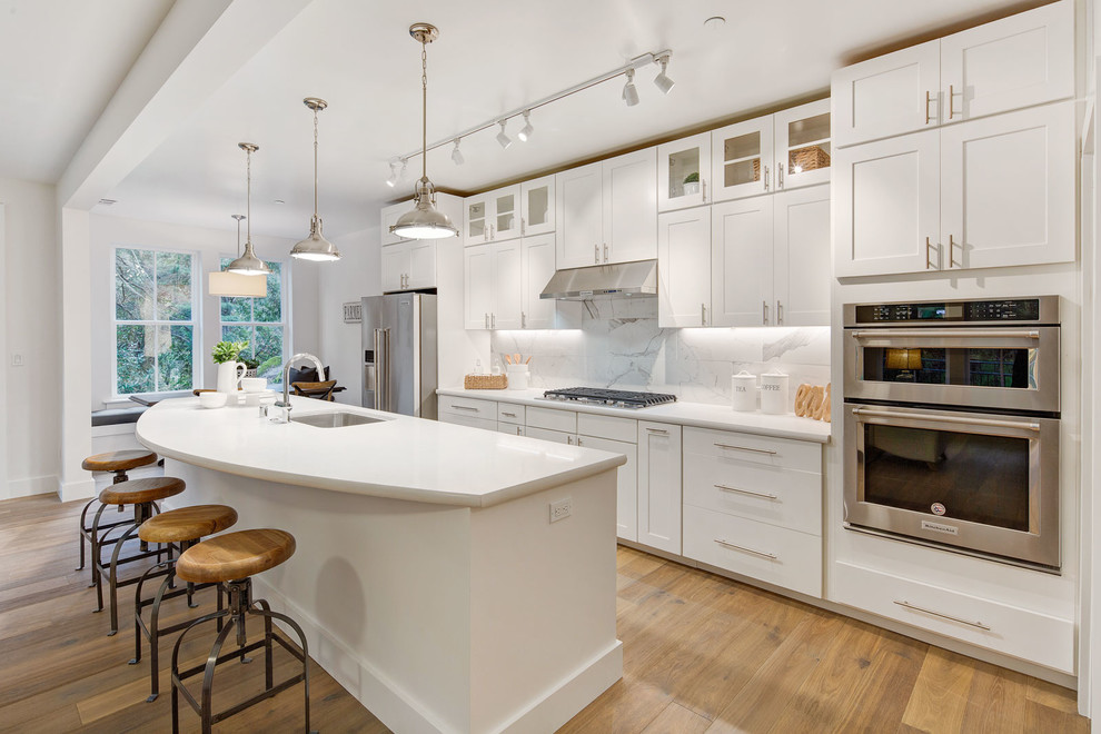 Idéer för att renovera ett stort lantligt vit vitt kök, med en enkel diskho, skåp i shakerstil, grå skåp, bänkskiva i kvarts, vitt stänkskydd, stänkskydd i keramik, rostfria vitvaror, mellanmörkt trägolv, en köksö och brunt golv