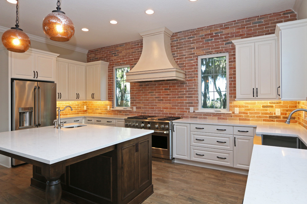 Foto på ett avskilt, mellanstort lantligt u-kök, med en rustik diskho, luckor med upphöjd panel, vita skåp, bänkskiva i koppar, rött stänkskydd, stänkskydd i tegel, rostfria vitvaror, mörkt trägolv och en köksö