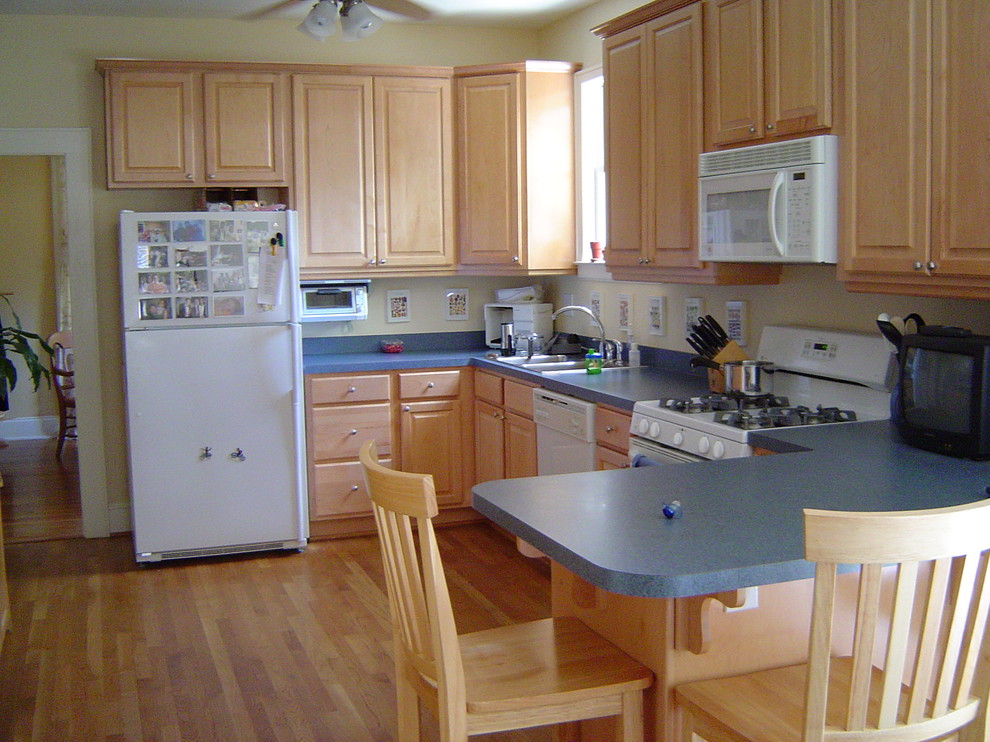 Idéer för att renovera ett mellanstort vintage kök, med en dubbel diskho, luckor med upphöjd panel, skåp i ljust trä, laminatbänkskiva, gult stänkskydd, vita vitvaror, mellanmörkt trägolv och en halv köksö