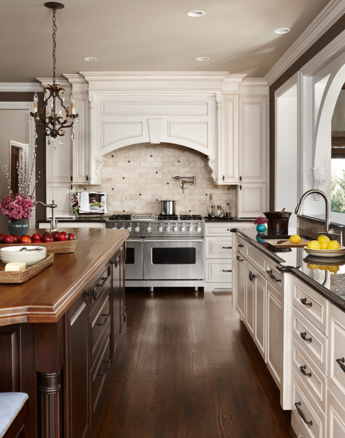 Exempel på ett lantligt kök, med en undermonterad diskho, luckor med upphöjd panel, vita skåp, träbänkskiva, vitt stänkskydd, stänkskydd i keramik, rostfria vitvaror, mörkt trägolv, en köksö och brunt golv