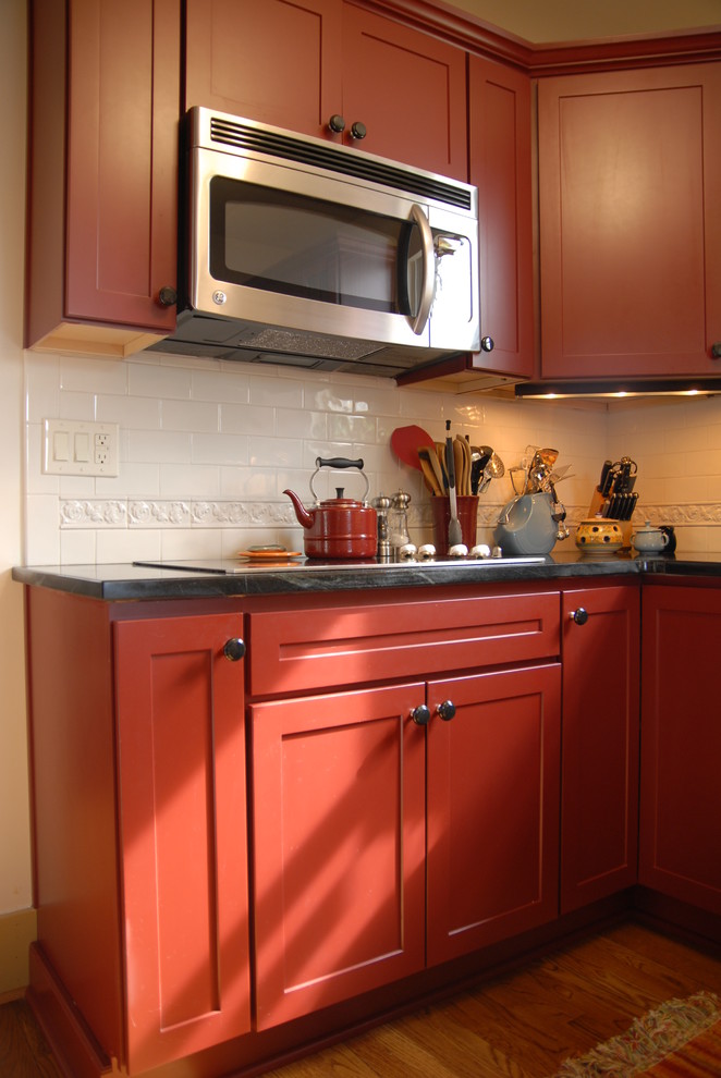 Medium sized farmhouse kitchen in Other with recessed-panel cabinets, red cabinets, soapstone worktops, white splashback, ceramic splashback, stainless steel appliances and light hardwood flooring.