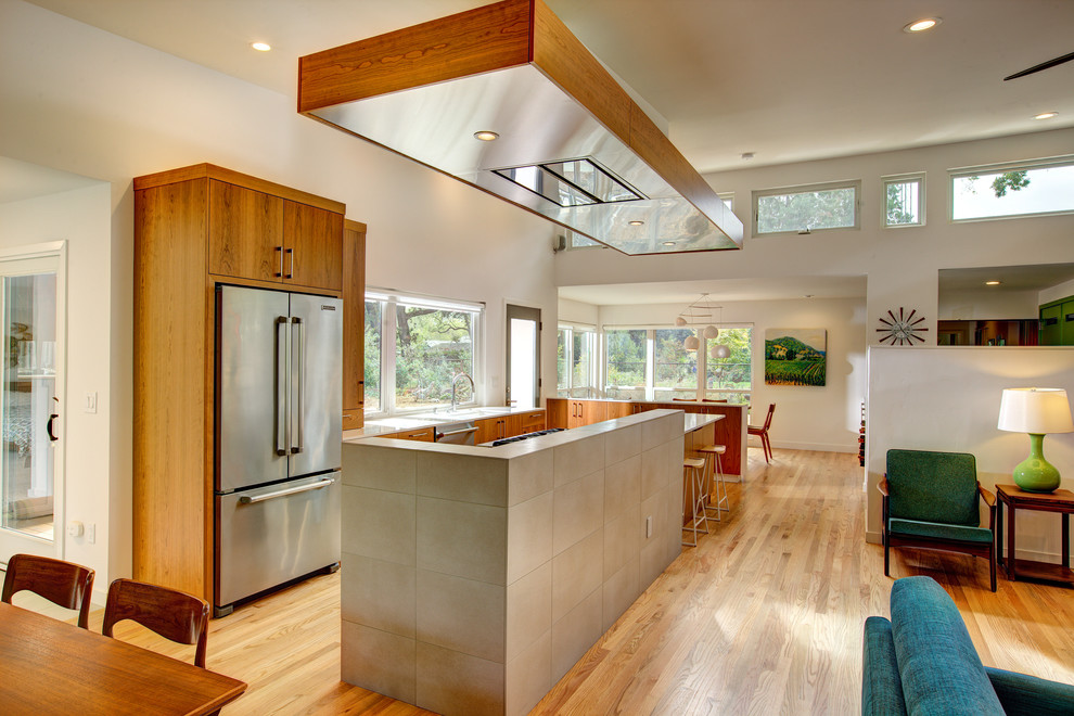 Exemple d'une cuisine ouverte rétro en bois foncé de taille moyenne avec un évier encastré, un placard à porte plane, un plan de travail en quartz modifié, un électroménager en acier inoxydable et parquet clair.