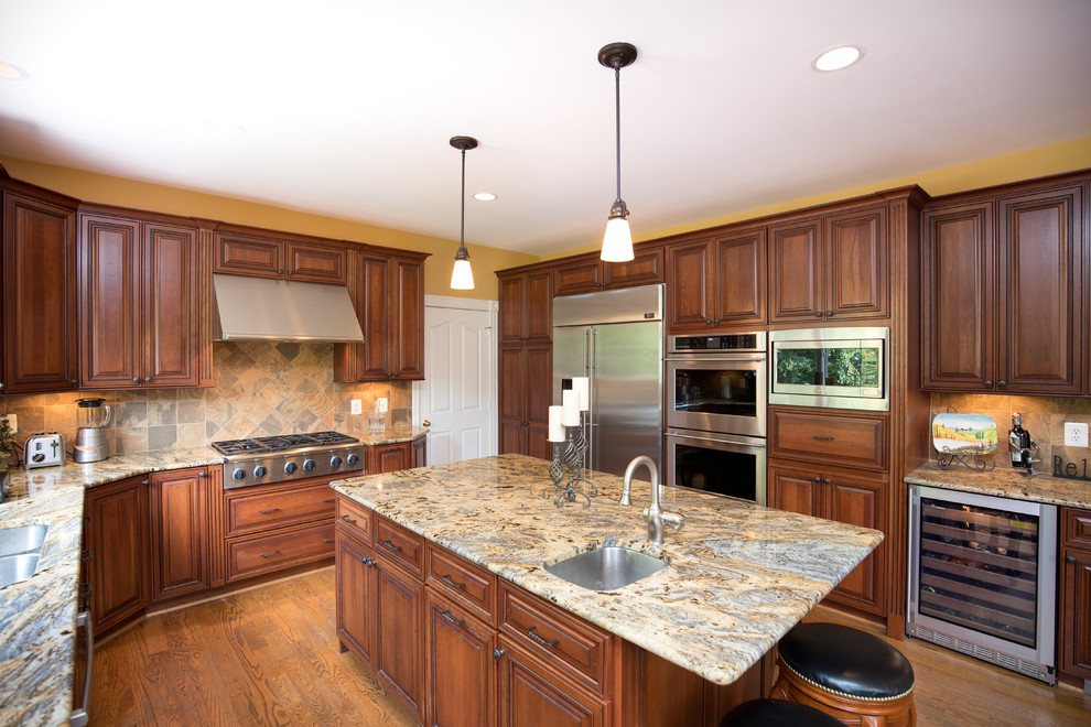 Inspiration for a mid-sized transitional u-shaped medium tone wood floor eat-in kitchen remodel in DC Metro with an undermount sink, raised-panel cabinets, dark wood cabinets, granite countertops, beige backsplash, stone tile backsplash, stainless steel appliances and an island