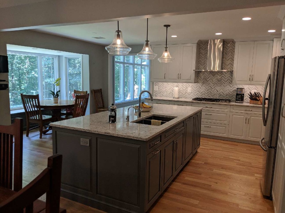 Example of a large transitional l-shaped medium tone wood floor eat-in kitchen design in DC Metro with raised-panel cabinets, white cabinets, quartz countertops, marble backsplash, stainless steel appliances, an island and multicolored countertops