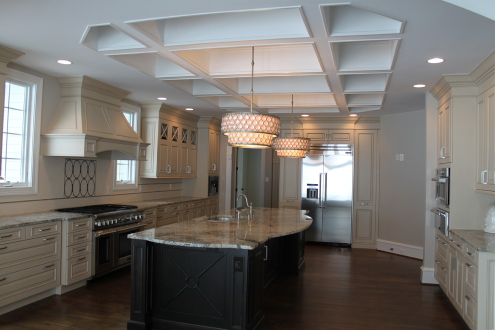 Exempel på ett stort klassiskt kök och matrum, med en köksö, en dubbel diskho, luckor med upphöjd panel, beige skåp, rostfria vitvaror, granitbänkskiva, beige stänkskydd, stänkskydd i keramik och mörkt trägolv