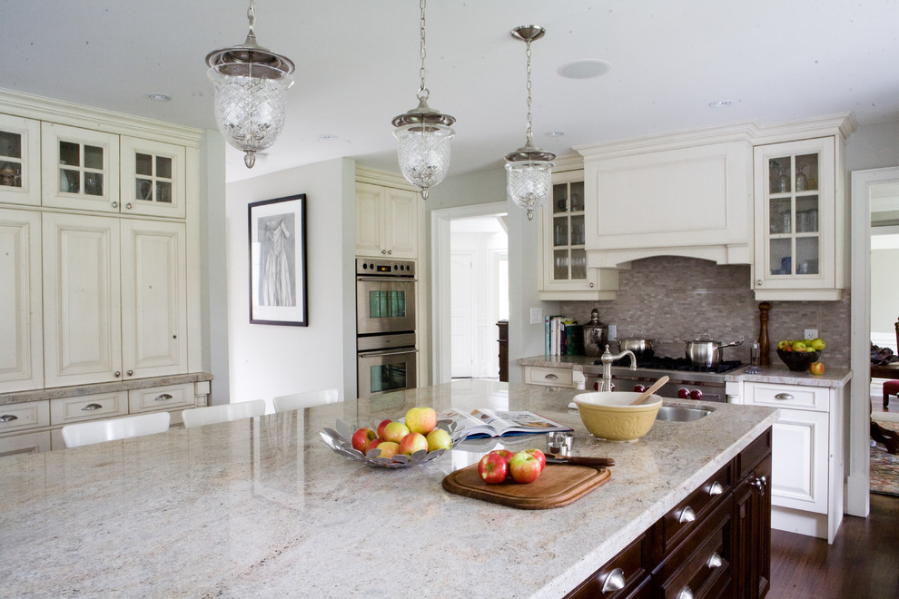 Example of a classic kitchen design in Toronto with glass-front cabinets, stainless steel appliances, white cabinets and granite countertops