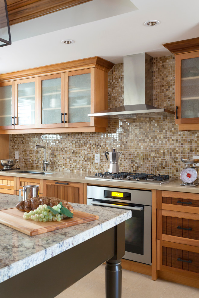 Exempel på ett klassiskt kök, med en dubbel diskho, skåp i mellenmörkt trä, brunt stänkskydd, stänkskydd i mosaik, rostfria vitvaror och en köksö