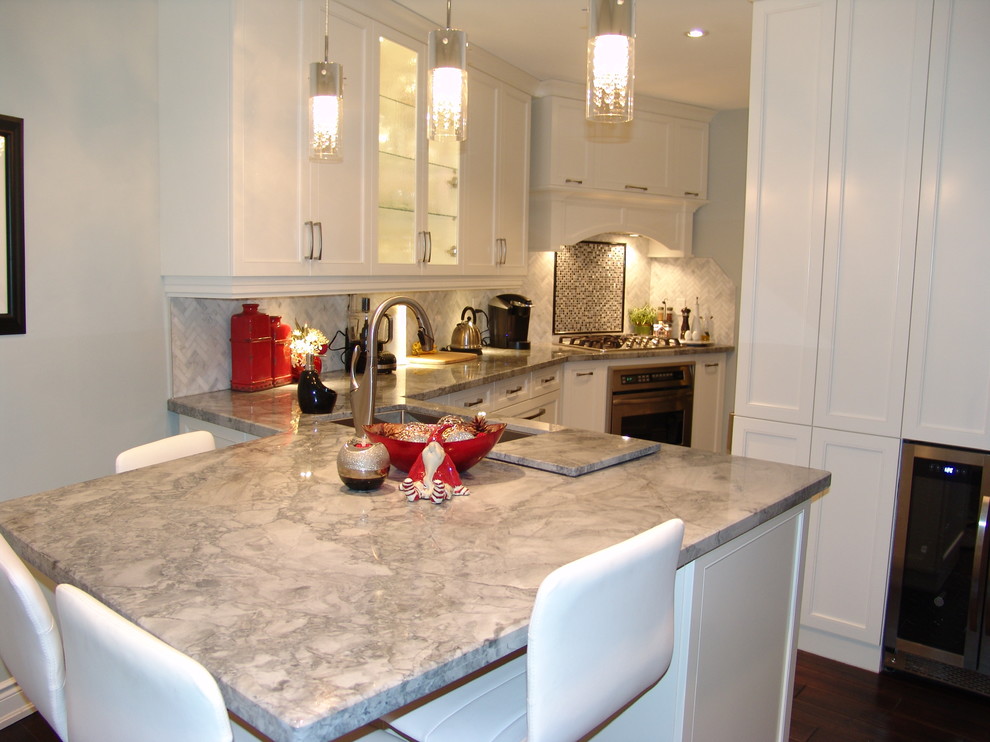 This is an example of a medium sized classic galley kitchen/diner in Toronto with a submerged sink, shaker cabinets, white cabinets, quartz worktops, white splashback, stone tiled splashback, stainless steel appliances, medium hardwood flooring and a breakfast bar.