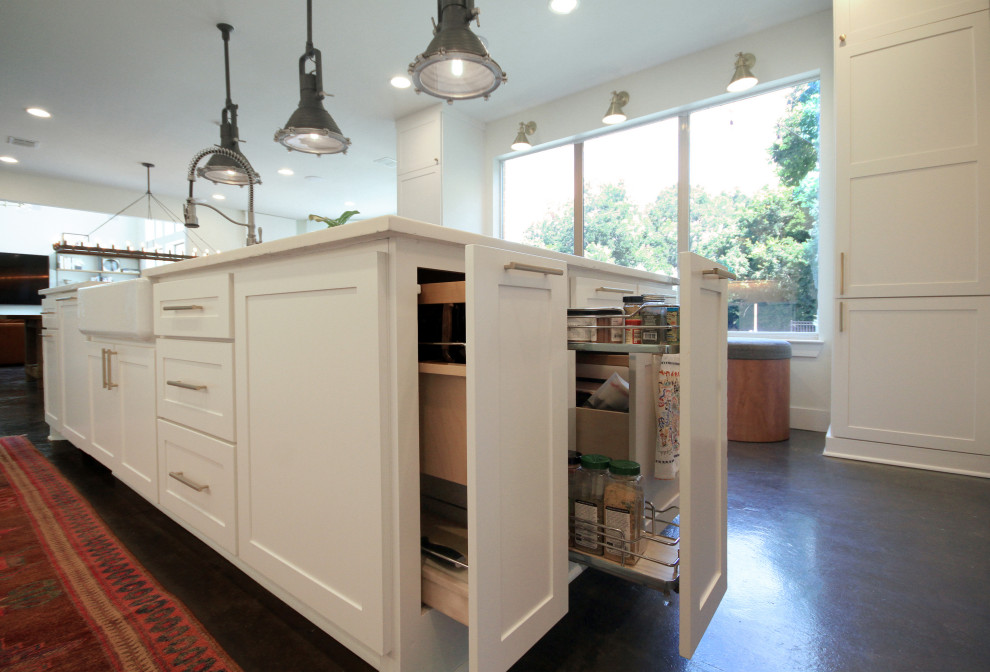 Klassisk inredning av ett stort vit vitt kök och matrum, med en rustik diskho, skåp i shakerstil, vita skåp, bänkskiva i kvarts, vitt stänkskydd, stänkskydd i tegel, integrerade vitvaror, betonggolv, en köksö och grått golv