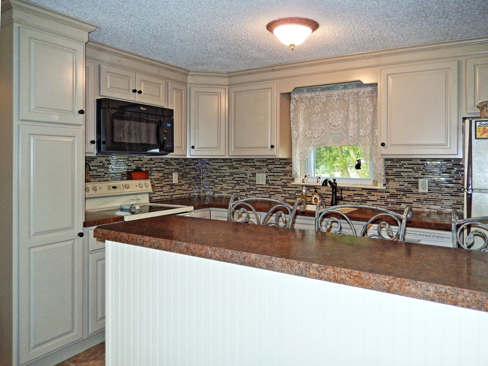 Example of a small classic l-shaped ceramic tile eat-in kitchen design in Other with an undermount sink, raised-panel cabinets, gray cabinets, laminate countertops, brown backsplash, mosaic tile backsplash, colored appliances and an island