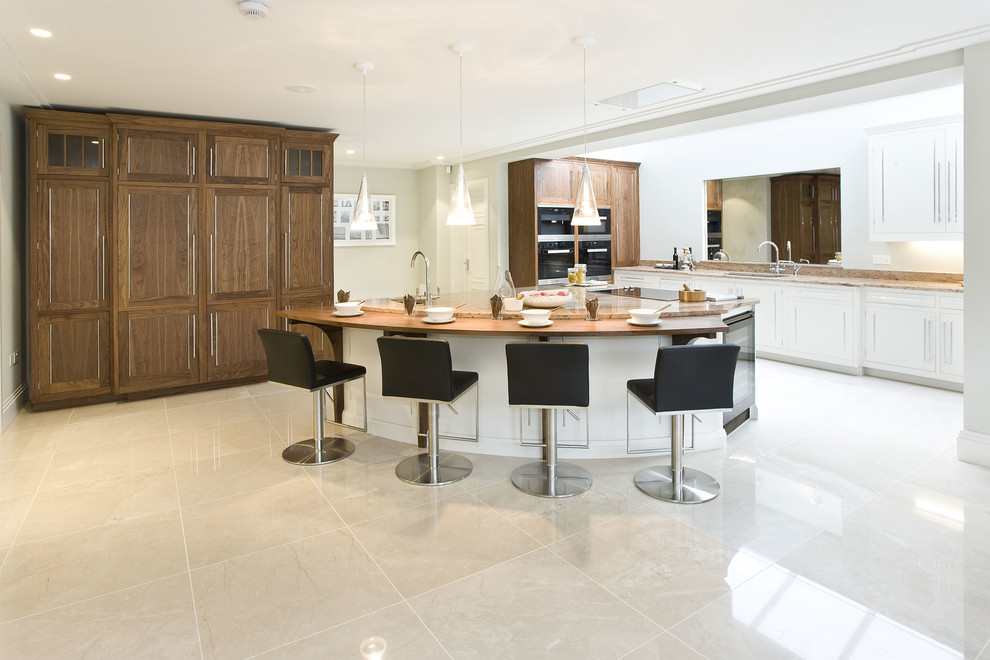 Esempio di un cucina con isola centrale design con ante in legno bruno, paraspruzzi a specchio, elettrodomestici neri, pavimento beige e top beige