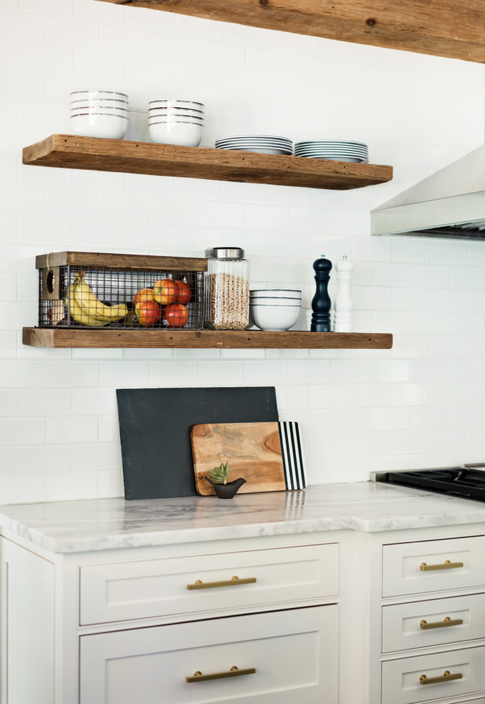 Exempel på ett stort lantligt kök och matrum, med luckor med profilerade fronter, vita skåp, marmorbänkskiva, vitt stänkskydd, stänkskydd i tunnelbanekakel, rostfria vitvaror och en köksö