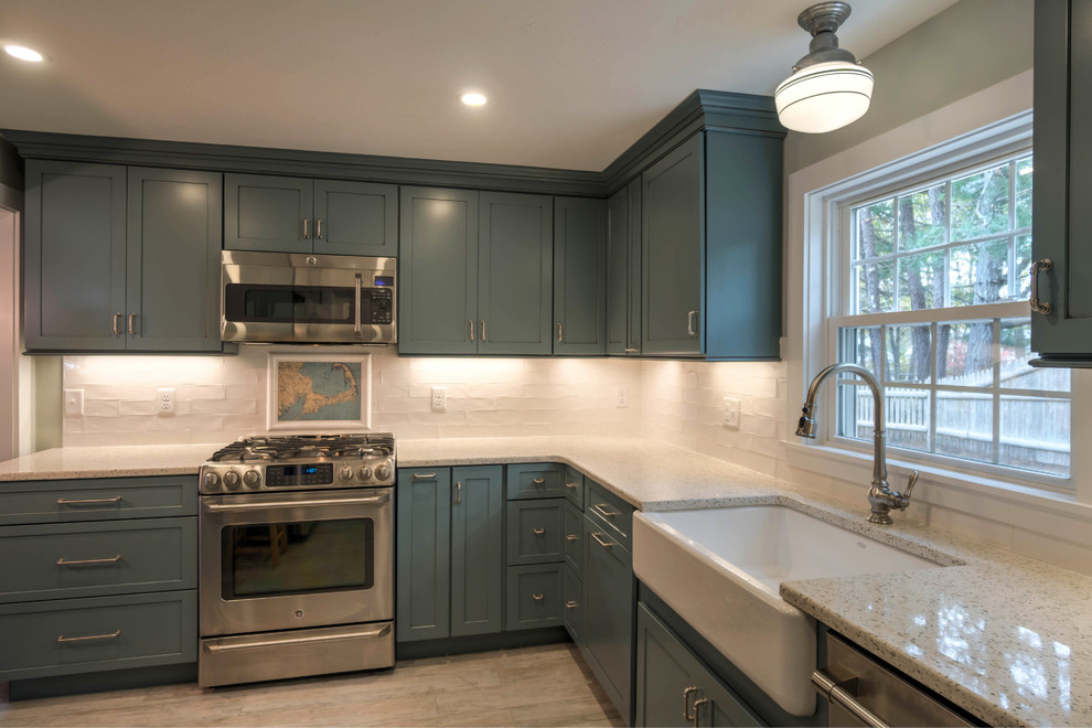 Inspiration for a small modern l-shaped kitchen pantry in Boston with a belfast sink, shaker cabinets, blue cabinets, recycled glass countertops, white splashback, ceramic splashback, stainless steel appliances, ceramic flooring, an island and beige floors.