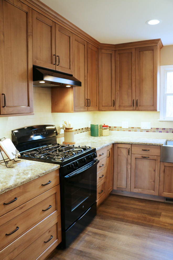 Exempel på ett mellanstort klassiskt kök, med en rustik diskho, luckor med infälld panel, skåp i ljust trä, bänkskiva i kvarts, beige stänkskydd, stänkskydd i stenkakel, svarta vitvaror, målat trägolv och en köksö