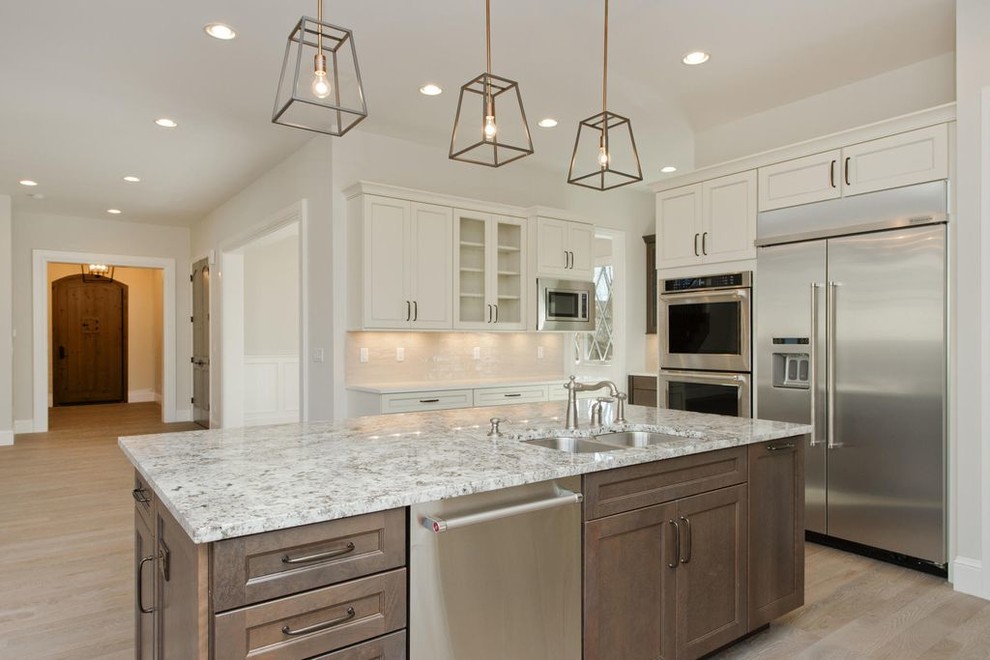 Eat-in kitchen - large traditional l-shaped eat-in kitchen idea in Denver with an undermount sink, shaker cabinets, white cabinets, beige backsplash, matchstick tile backsplash, stainless steel appliances and an island