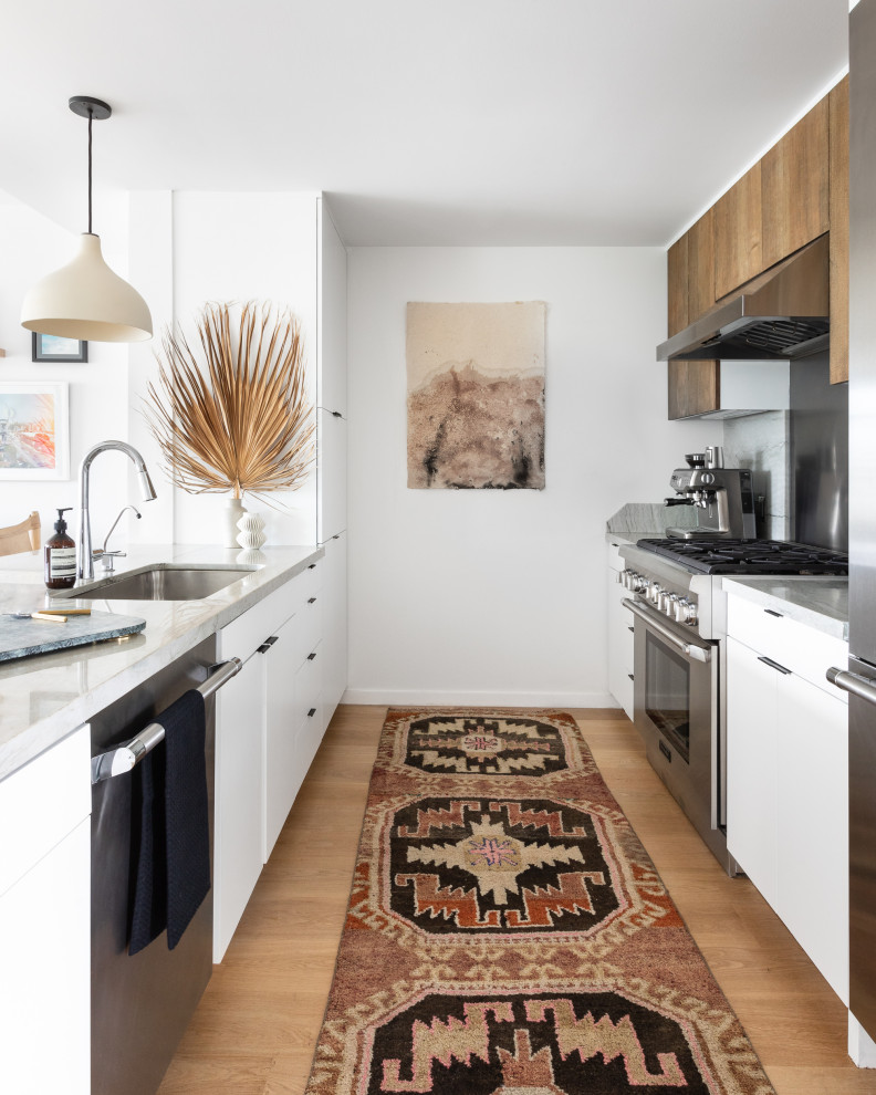 Foto på ett mellanstort maritimt grå kök, med en undermonterad diskho, släta luckor, bruna skåp, marmorbänkskiva, rostfria vitvaror, en halv köksö, brunt golv, grått stänkskydd, stänkskydd i marmor och mellanmörkt trägolv