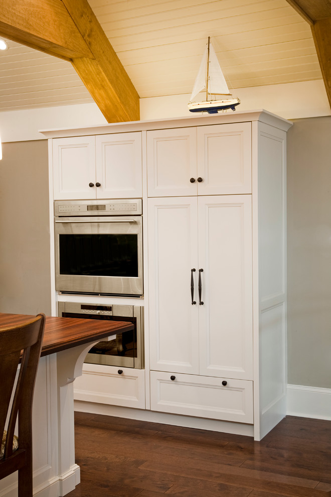 Foto de cocina tradicional grande con armarios con paneles empotrados, puertas de armario blancas, suelo de madera oscura, una isla y electrodomésticos de acero inoxidable