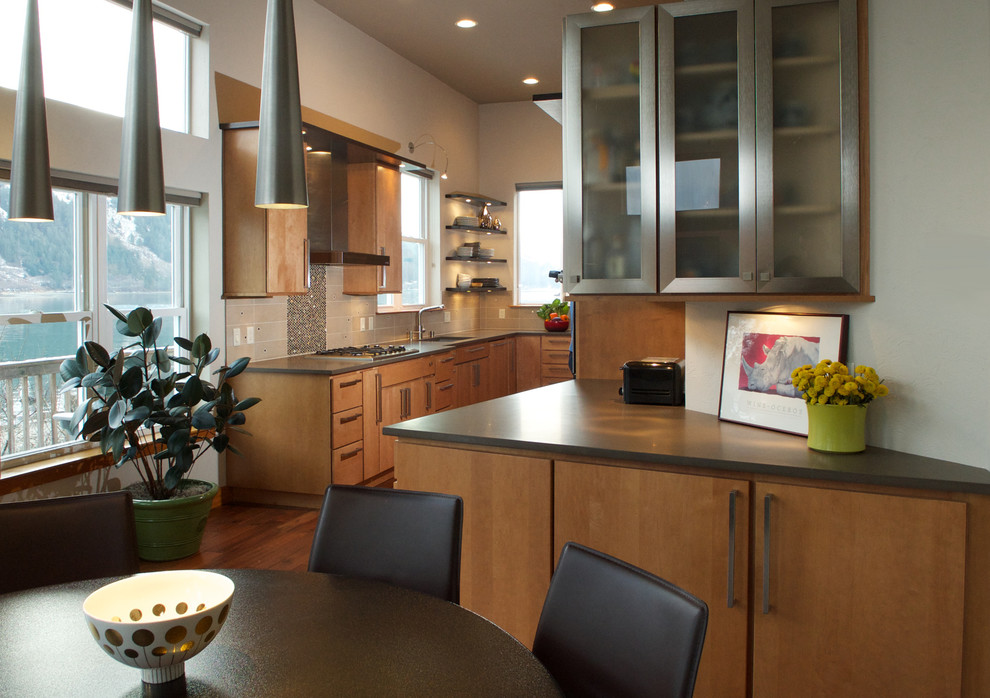 Modern inredning av ett kök, med en undermonterad diskho, luckor med glaspanel, skåp i rostfritt stål, bänkskiva i kvarts, beige stänkskydd, stänkskydd i stenkakel, rostfria vitvaror och mellanmörkt trägolv