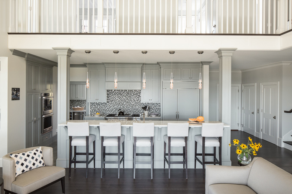 Exempel på ett klassiskt linjärt kök med öppen planlösning, med skåp i shakerstil, grå skåp, granitbänkskiva, flerfärgad stänkskydd, stänkskydd i mosaik, rostfria vitvaror, mörkt trägolv och en köksö
