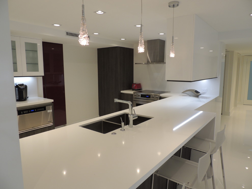 Mittelgroße Moderne Wohnküche in L-Form mit Doppelwaschbecken, flächenbündigen Schrankfronten, Küchenrückwand in Weiß, Küchengeräten aus Edelstahl, Porzellan-Bodenfliesen, weißen Schränken, Quarzit-Arbeitsplatte und Kücheninsel in Miami
