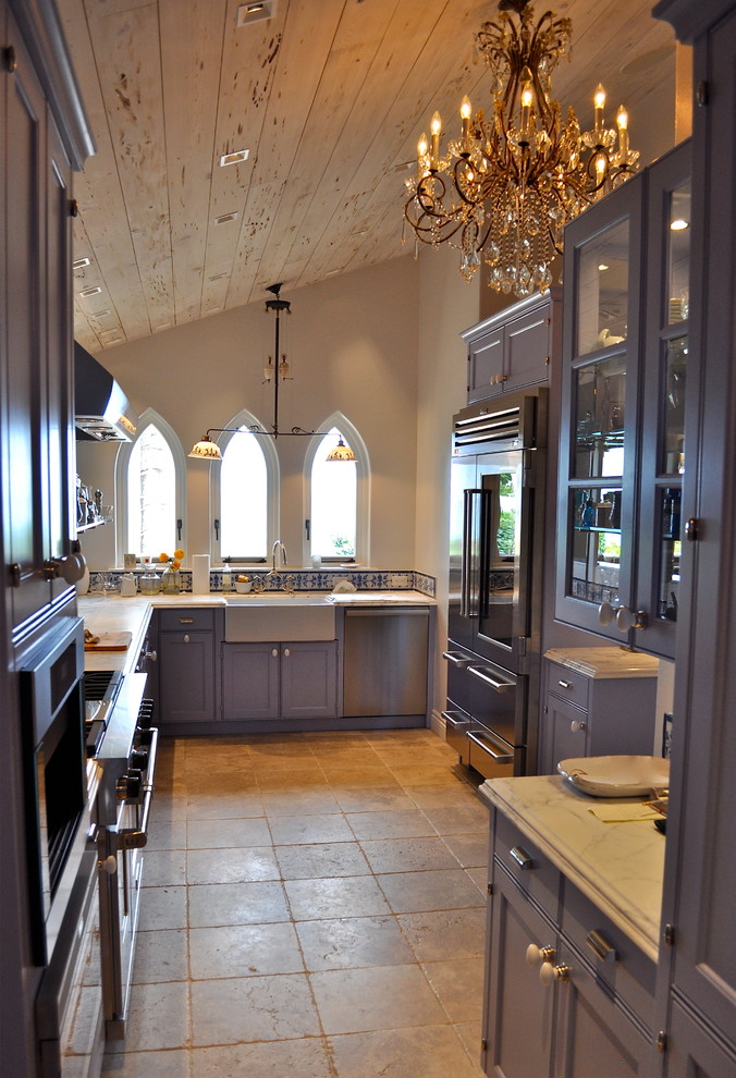 Example of a mid-sized classic galley travertine floor enclosed kitchen design in Charlotte with a farmhouse sink, beaded inset cabinets, marble countertops, multicolored backsplash, stainless steel appliances, no island, porcelain backsplash and brown cabinets