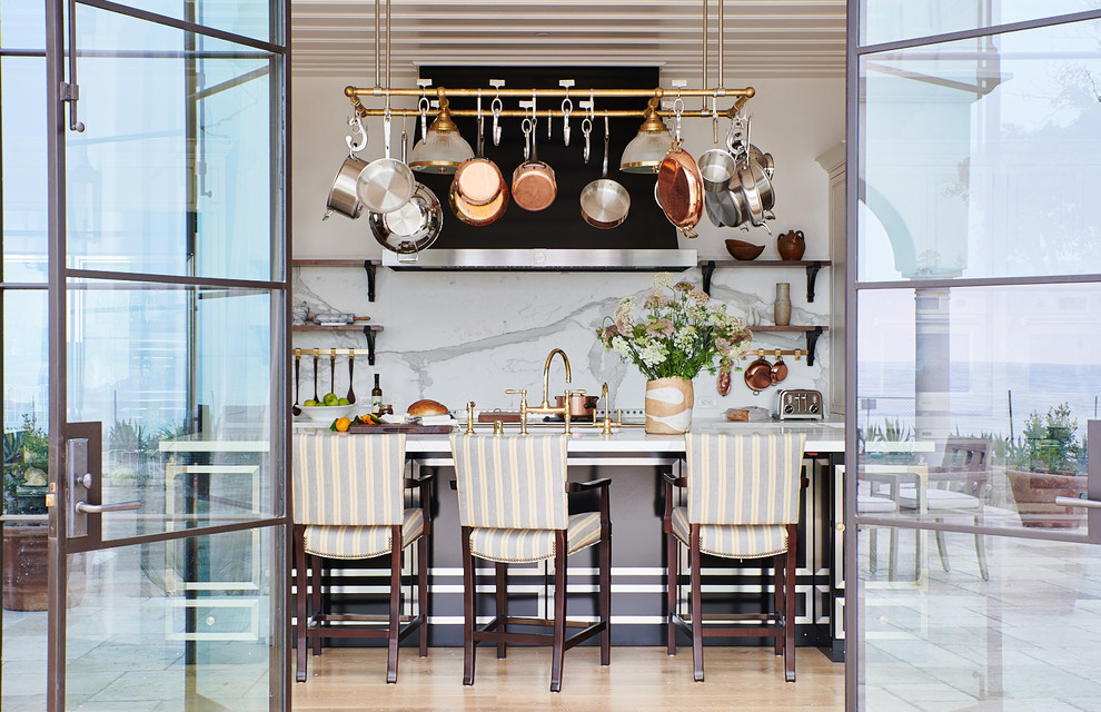 Foto di una cucina mediterranea con lavello sottopiano, ante lisce, ante nere, paraspruzzi bianco, top bianco, pavimento in legno massello medio e pavimento marrone
