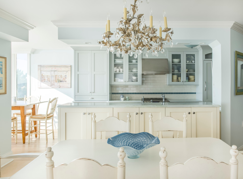 Immagine di una cucina stile marinaro di medie dimensioni con ante blu, parquet chiaro, lavello sottopiano, ante con riquadro incassato, paraspruzzi bianco, paraspruzzi con piastrelle diamantate e elettrodomestici da incasso