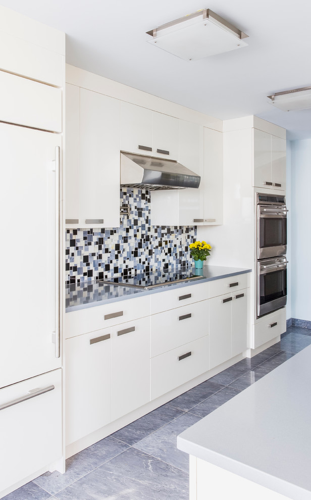 Diseño de cocina comedor actual de tamaño medio con armarios con paneles lisos, puertas de armario blancas, salpicadero multicolor, salpicadero con mosaicos de azulejos y electrodomésticos de acero inoxidable