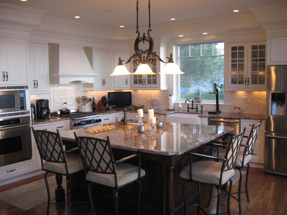 Example of a mid-sized classic l-shaped medium tone wood floor eat-in kitchen design in Providence with a farmhouse sink, beaded inset cabinets, white cabinets, granite countertops, yellow backsplash, ceramic backsplash, stainless steel appliances and an island