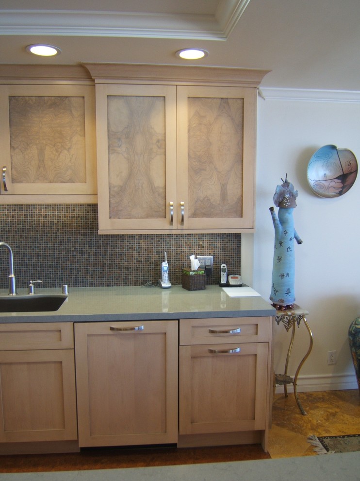 Idée de décoration pour une cuisine ouverte parallèle design en bois clair de taille moyenne avec un placard à porte shaker et un plan de travail en quartz modifié.