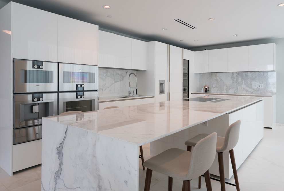 Esempio di una grande cucina moderna con ante lisce, ante bianche, paraspruzzi in marmo, elettrodomestici in acciaio inossidabile e pavimento bianco