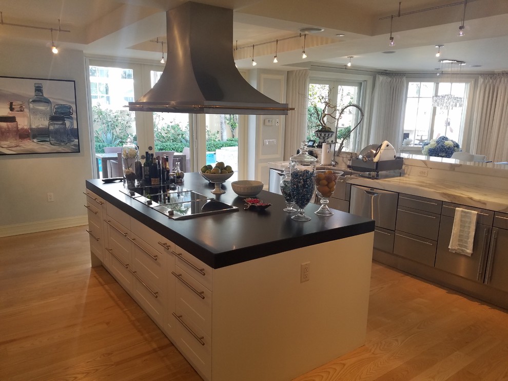 Design ideas for a large nautical u-shaped kitchen pantry in Miami with a belfast sink, shaker cabinets, white cabinets, marble worktops, white splashback, marble splashback, stainless steel appliances, light hardwood flooring and an island.
