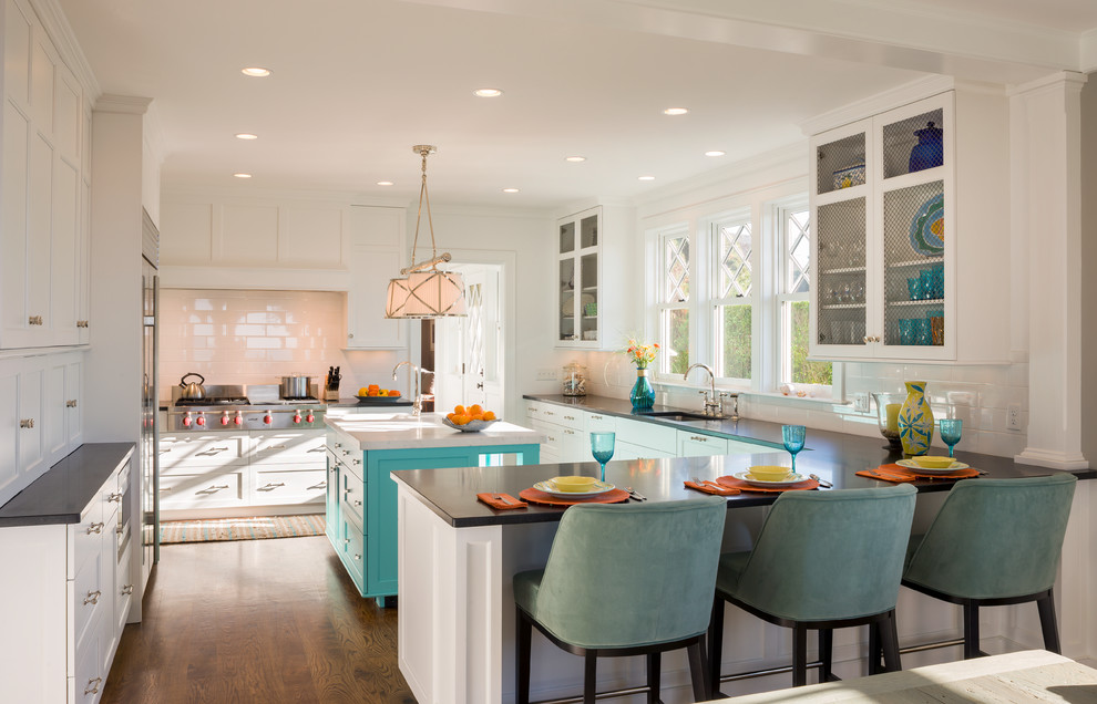 Example of a beach style u-shaped eat-in kitchen design in Providence with glass-front cabinets, white cabinets, white backsplash and subway tile backsplash