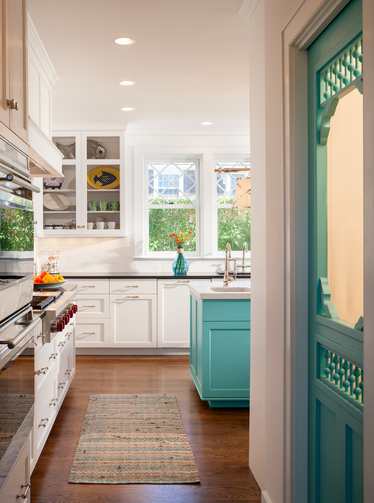 Cette image montre une cuisine marine avec un placard à porte shaker, des portes de placard blanches, une crédence blanche et une crédence en carrelage métro.