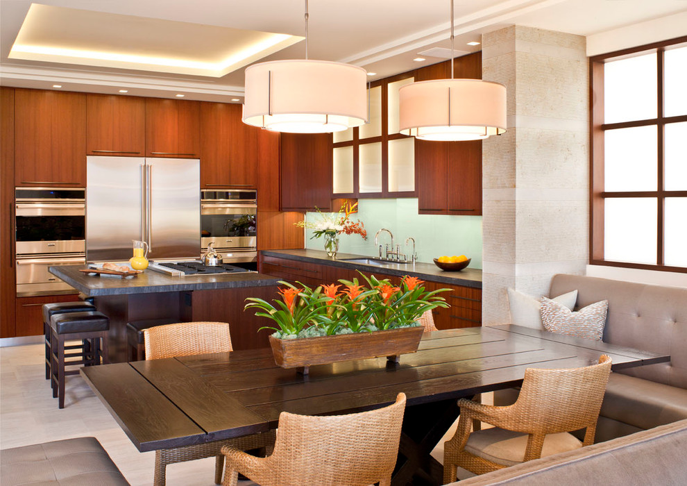 Eat-in kitchen - contemporary l-shaped porcelain tile eat-in kitchen idea in Los Angeles with flat-panel cabinets, medium tone wood cabinets, green backsplash, glass sheet backsplash, stainless steel appliances, an undermount sink and an island