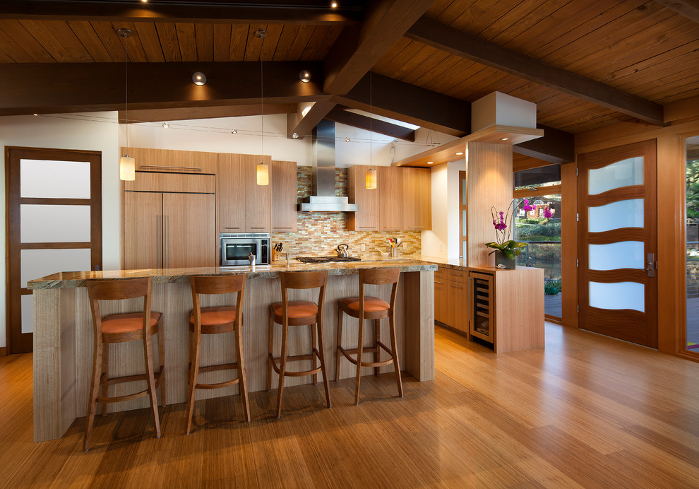 Inspiration for a mid-sized modern single-wall bamboo floor open concept kitchen remodel in Santa Barbara with a single-bowl sink, flat-panel cabinets, light wood cabinets, granite countertops, multicolored backsplash, glass tile backsplash, paneled appliances and an island