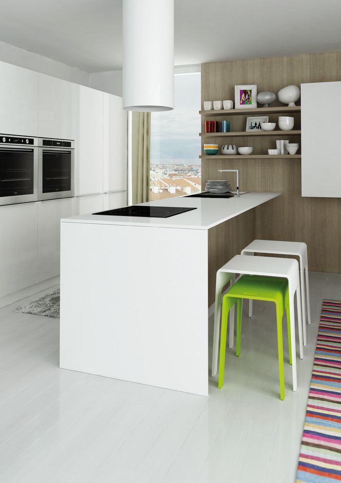 Ejemplo de cocina comedor minimalista con electrodomésticos de acero inoxidable y península