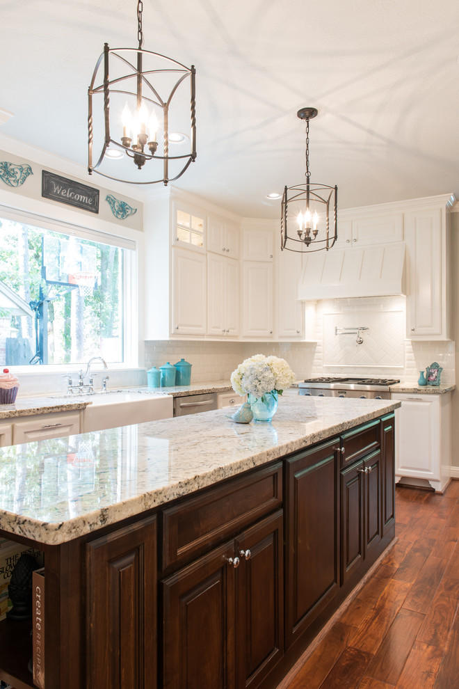 Eat-in kitchen - large transitional u-shaped medium tone wood floor eat-in kitchen idea in Houston with a farmhouse sink, raised-panel cabinets, white cabinets, granite countertops, white backsplash, ceramic backsplash, stainless steel appliances and an island