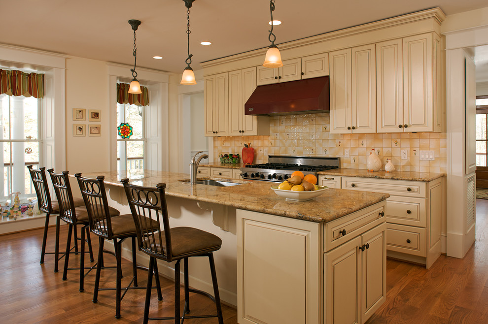 Mid-sized elegant galley medium tone wood floor eat-in kitchen photo in Baltimore with an undermount sink, raised-panel cabinets, beige cabinets, laminate countertops, black backsplash, ceramic backsplash, stainless steel appliances and an island
