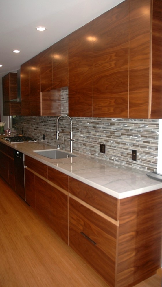 Example of a mid-sized minimalist galley bamboo floor eat-in kitchen design in Los Angeles with a double-bowl sink, flat-panel cabinets, medium tone wood cabinets, marble countertops, glass tile backsplash, stainless steel appliances, an island and multicolored backsplash
