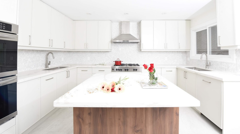 Inspiration for a mid-sized transitional u-shaped light wood floor and white floor open concept kitchen remodel in Toronto with an undermount sink, shaker cabinets, gray cabinets, quartzite countertops, white backsplash, metal backsplash, stainless steel appliances, an island and white countertops