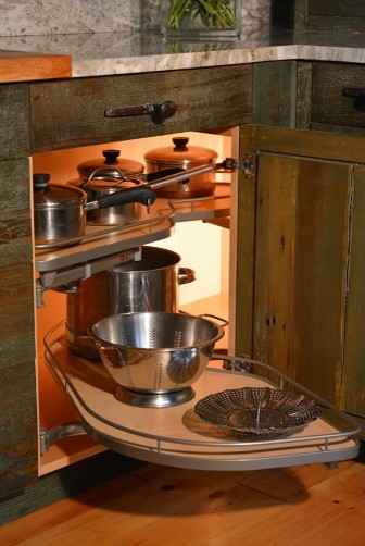 Bild på ett stort rustikt kök, med en undermonterad diskho, gröna skåp, granitbänkskiva, vita vitvaror, mellanmörkt trägolv, en halv köksö och skåp i shakerstil