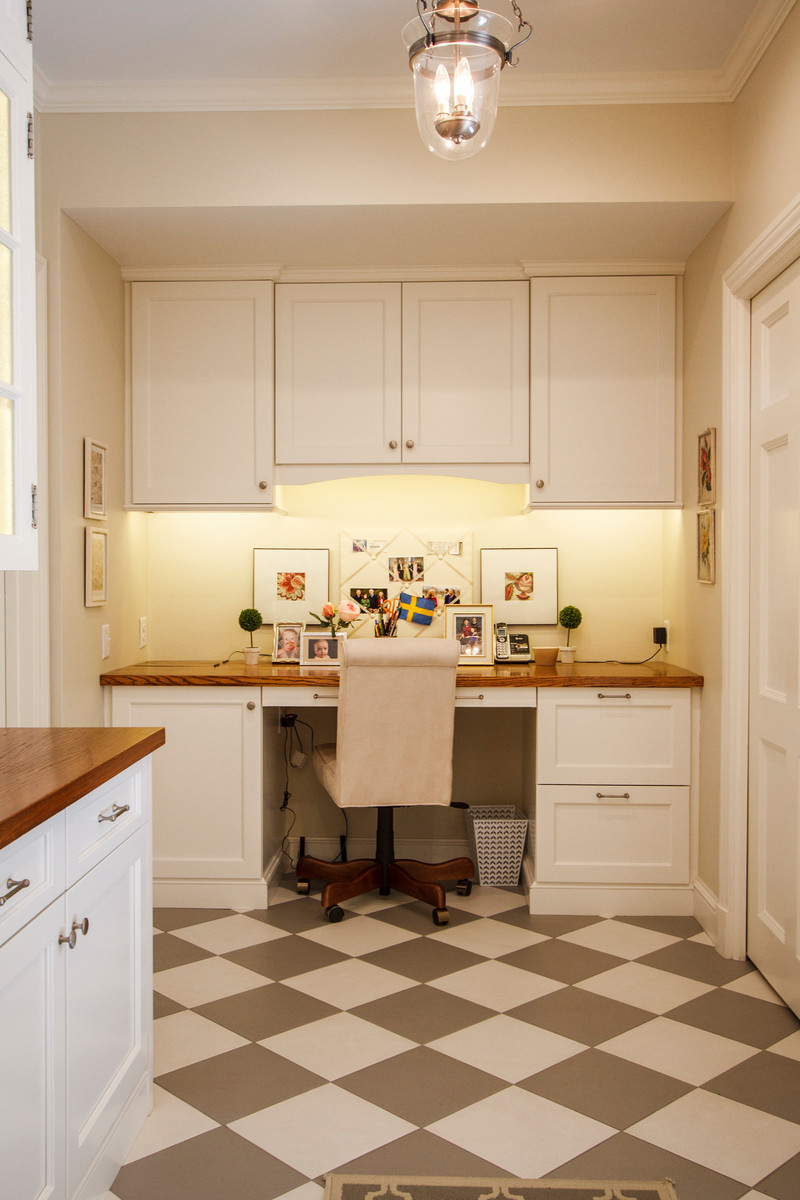 Klassisk inredning av ett stort kök, med en undermonterad diskho, luckor med infälld panel, vita skåp, bänkskiva i koppar, vitt stänkskydd, stänkskydd i keramik, rostfria vitvaror, klinkergolv i porslin och grått golv