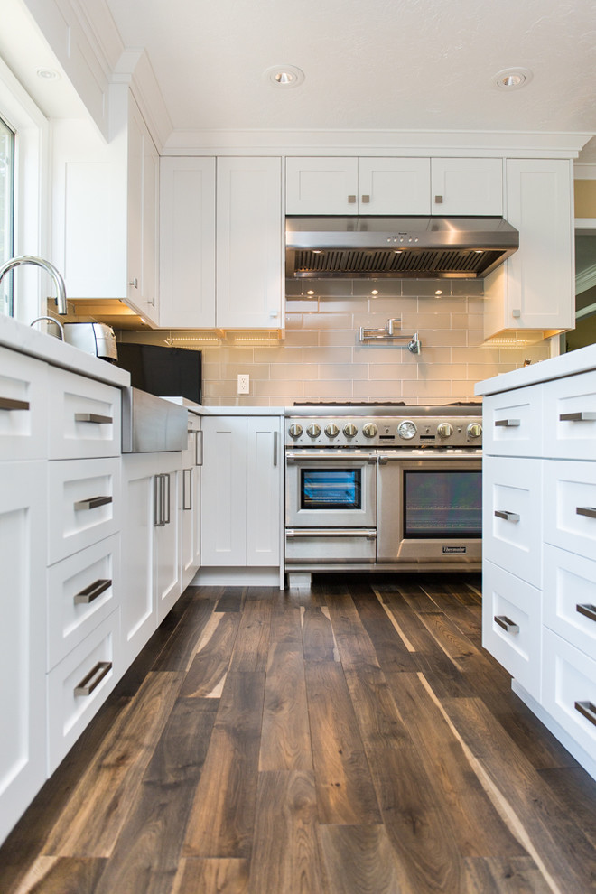 Design ideas for a medium sized contemporary l-shaped open plan kitchen in Salt Lake City with a belfast sink, shaker cabinets, white cabinets, stainless steel appliances and an island.