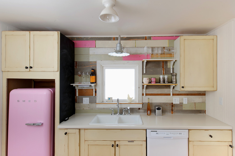 Aménagement d'une cuisine linéaire et grise et rose romantique en bois vieilli avec un évier posé et un électroménager de couleur.