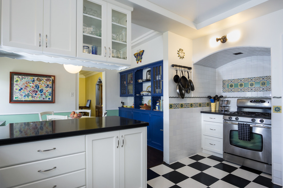 Foto på ett mellanstort vintage kök, med skåp i shakerstil, vita skåp, bänkskiva i kvarts, flerfärgad stänkskydd, stänkskydd i keramik, rostfria vitvaror, vinylgolv och en halv köksö