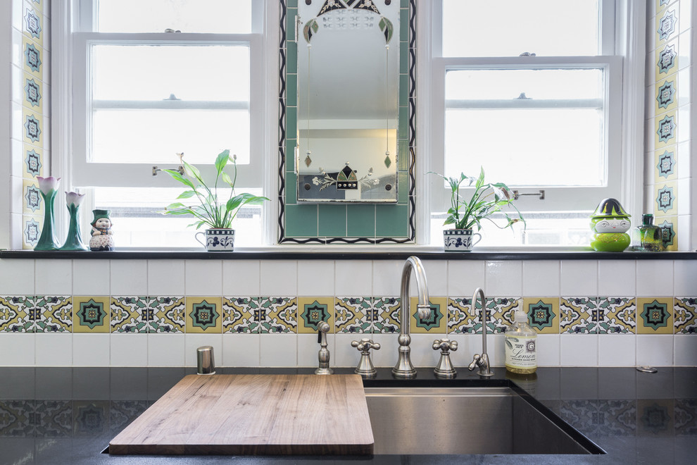 Medium sized traditional u-shaped kitchen/diner in Los Angeles with a submerged sink, white cabinets, engineered stone countertops, multi-coloured splashback, ceramic splashback, vinyl flooring and a breakfast bar.