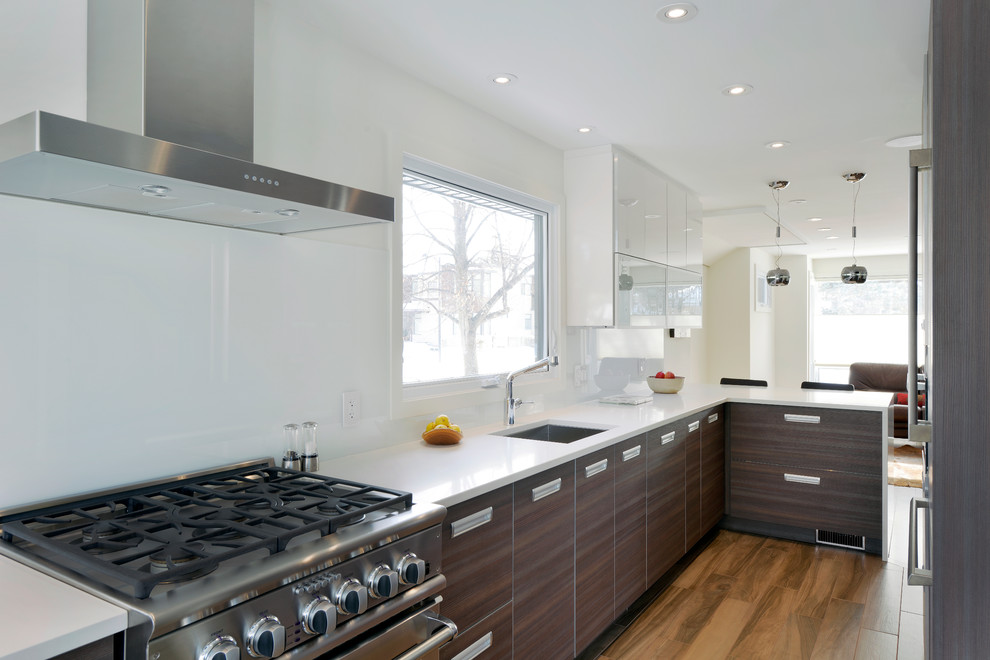 Example of a trendy eat-in kitchen design in Toronto with flat-panel cabinets and white backsplash