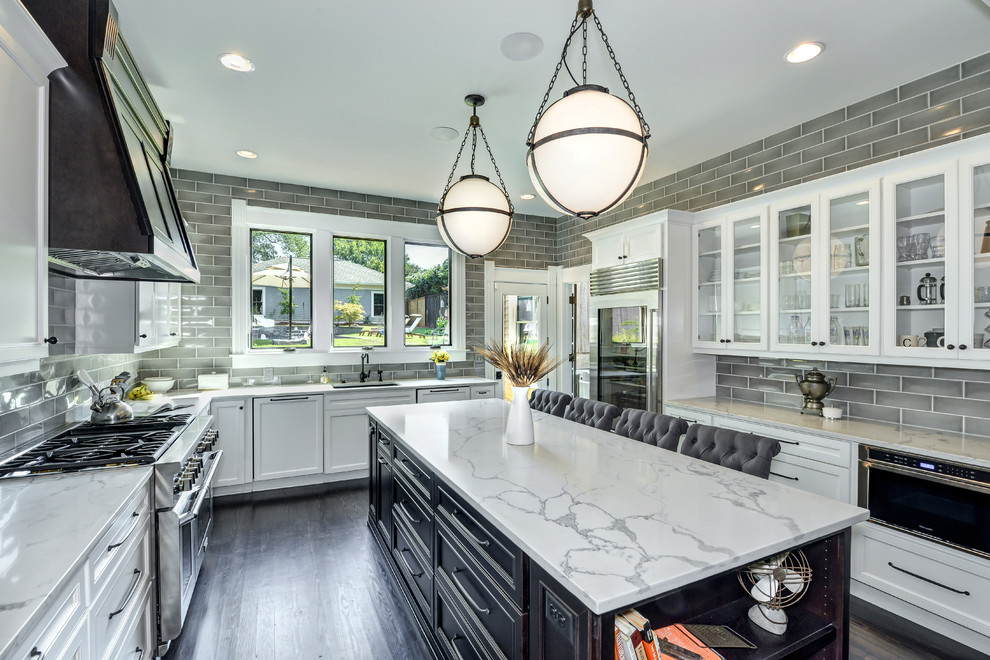 Photo of a large classic u-shaped kitchen in Atlanta with a submerged sink, white cabinets, engineered stone countertops, grey splashback, ceramic splashback, stainless steel appliances, dark hardwood flooring, an island and glass-front cabinets.