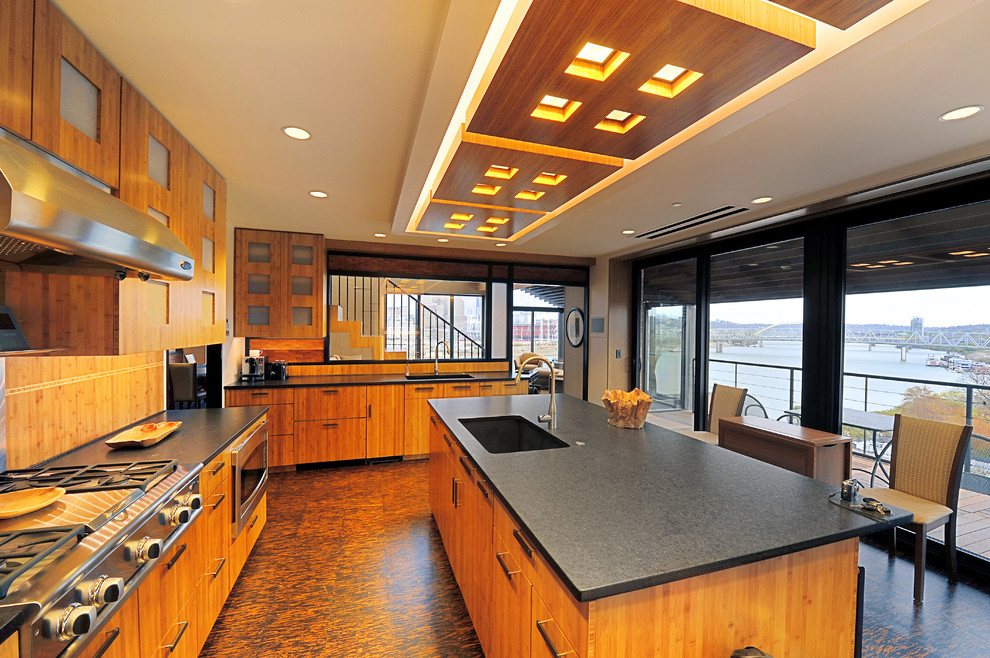 Exempel på ett mellanstort modernt kök, med en undermonterad diskho, släta luckor, skåp i mellenmörkt trä, granitbänkskiva, beige stänkskydd, korkgolv, en köksö, stänkskydd i trä, rostfria vitvaror och brunt golv
